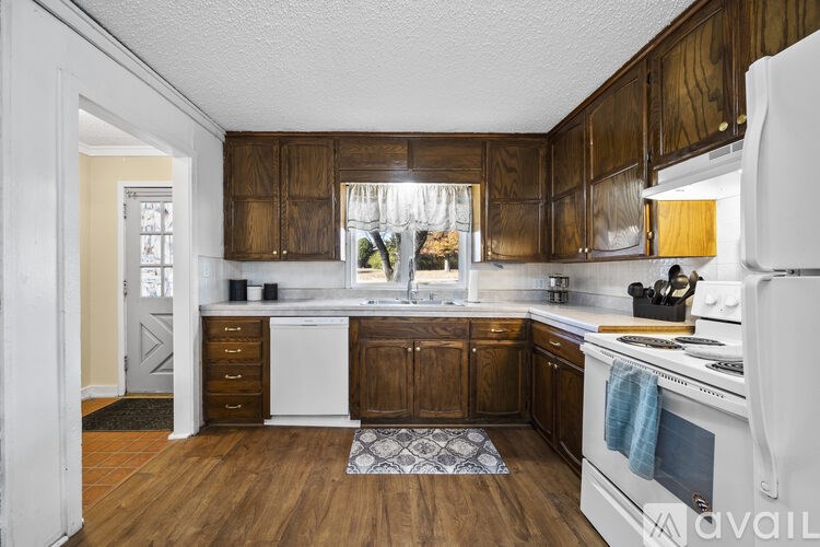 A kitchen with wooden cabinets and white appliances.