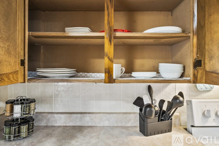 A kitchen with a white oven and a container of utensils on the counter.