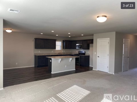 A spacious kitchen with dark wood cabinets and a white island.