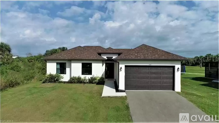 A house with a white exterior and a black garage door is for sale.