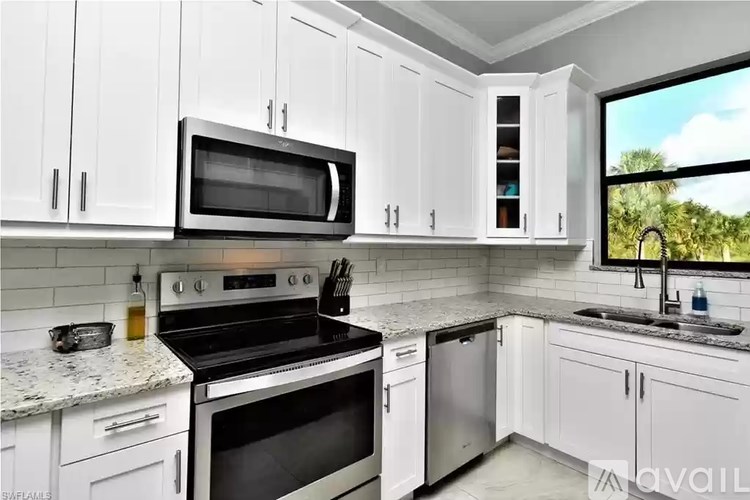 A kitchen with white cabinets and a black stove top oven.