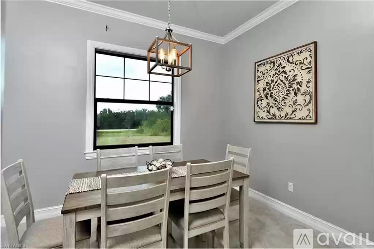 A dining room with a table and chairs.