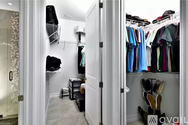 A walk in closet with clothes and shoes.