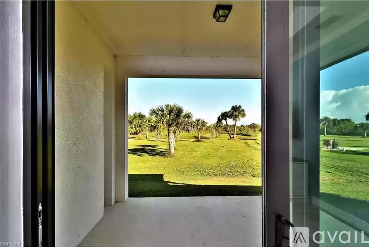 A view from a doorway looking out to a grassy area with trees.