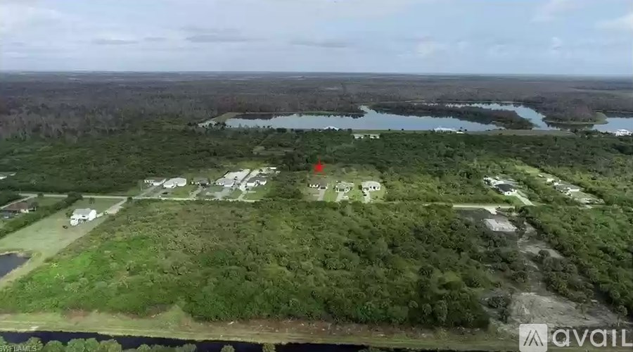 An aerial view of a residential area with a body of water in the distance.