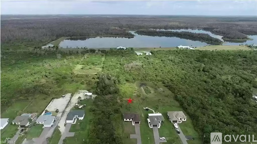 A bird's eye view of a residential area with a lake in the background.