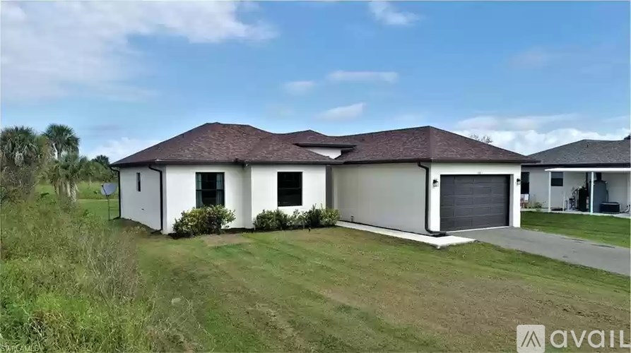 A house with a brown roof and white walls is for sale.