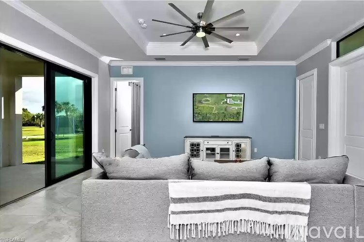 A modern living room with a grey sofa and a ceiling fan.