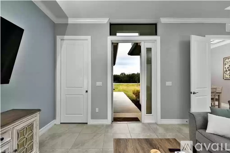 A modern interior with a view of a green landscape through a glass door.