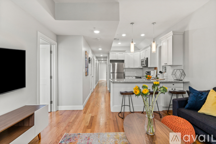 A modern kitchen with a long hallway leading to the dining area.
