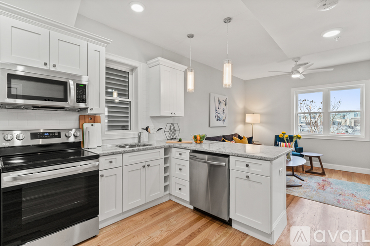A modern kitchen with white cabinets and stainless steel appliances.