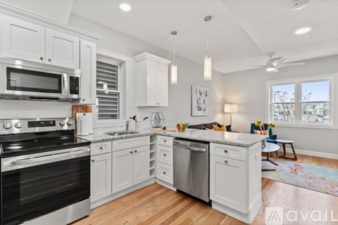 A modern kitchen with white cabinets and stainless steel appliances.