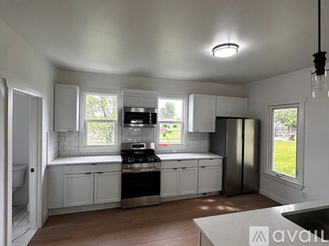 A kitchen with white cabinets and a black stove top oven.