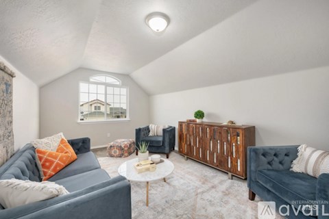 A living room with a grey couch, a wooden cabinet, and a small table with a plant on it.