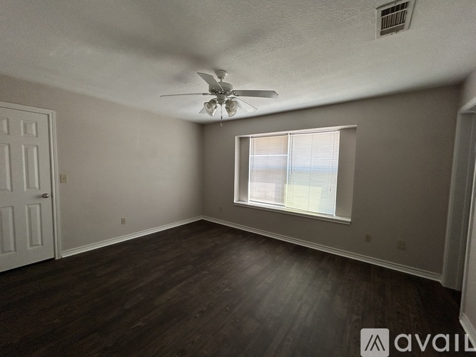 A room with a ceiling fan and a window.