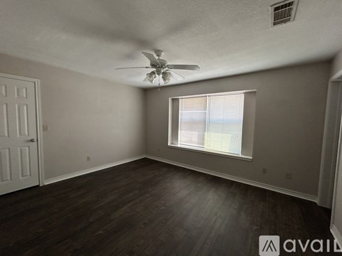 A room with a ceiling fan and a window.