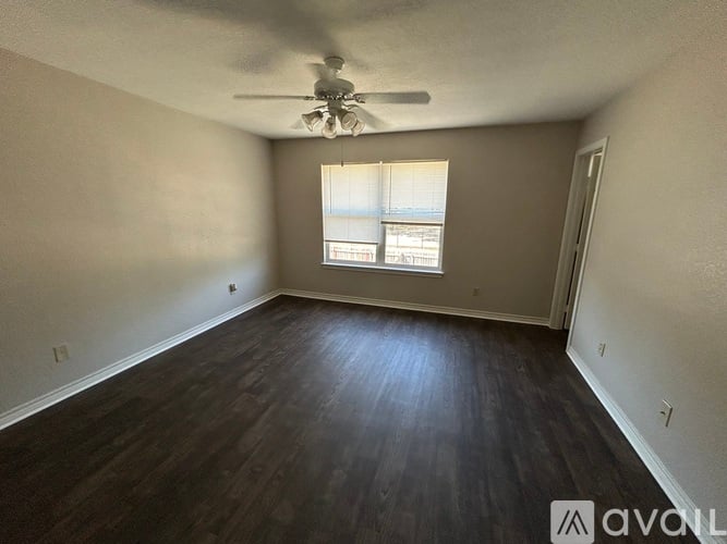A room with a ceiling fan and a window with blinds.