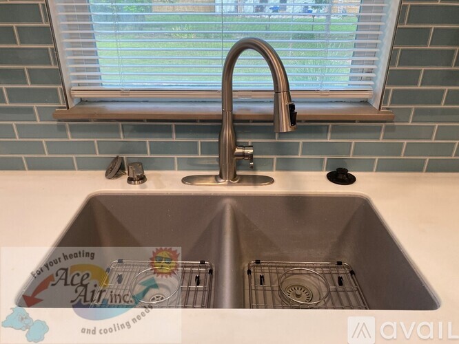 A kitchen sink with a faucet and a window above it.