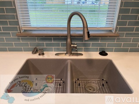 A kitchen sink with a faucet and a window above it.