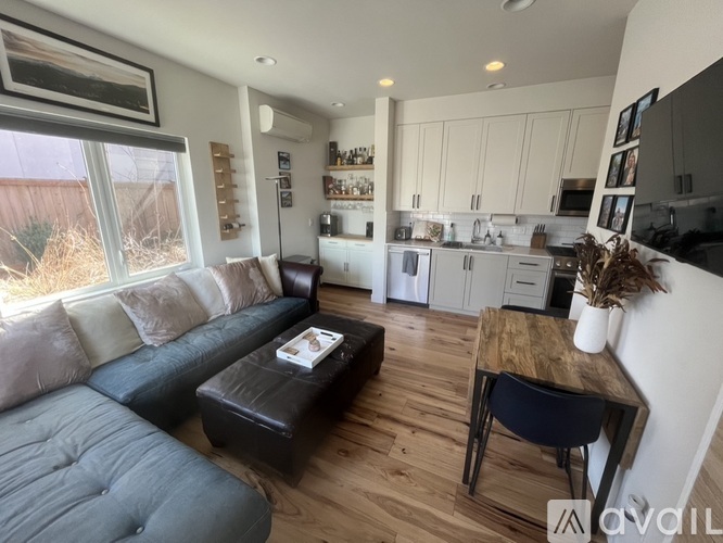 A living room with a grey couch and a brown ottoman.