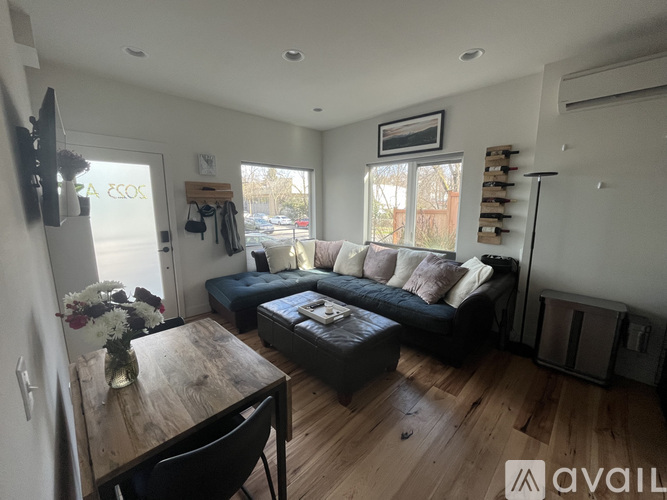 A living room with a couch, a table, and a window.
