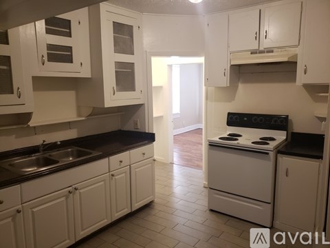 A kitchen with white cabinets and a black stove top oven.