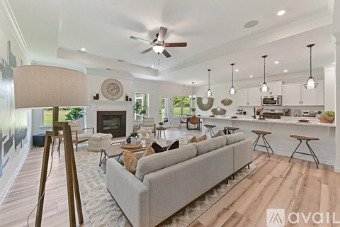A living room with a grey couch and a wooden floor.