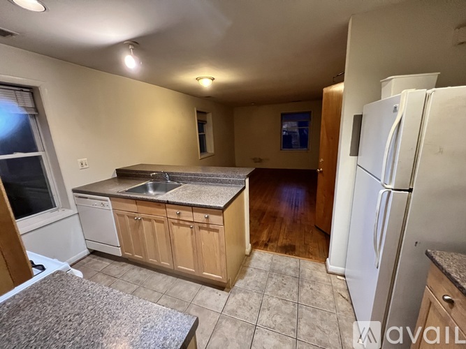 A kitchen with a white refrigerator and wooden cabinets.