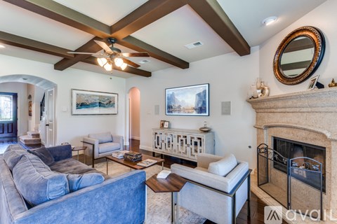 A living room with a blue couch and a fireplace.