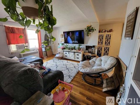 A living room with a grey couch and a white bean bag chair.