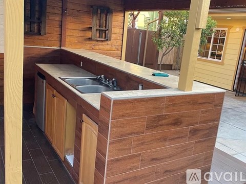 A kitchen with wooden cabinets and a sink under a counter.