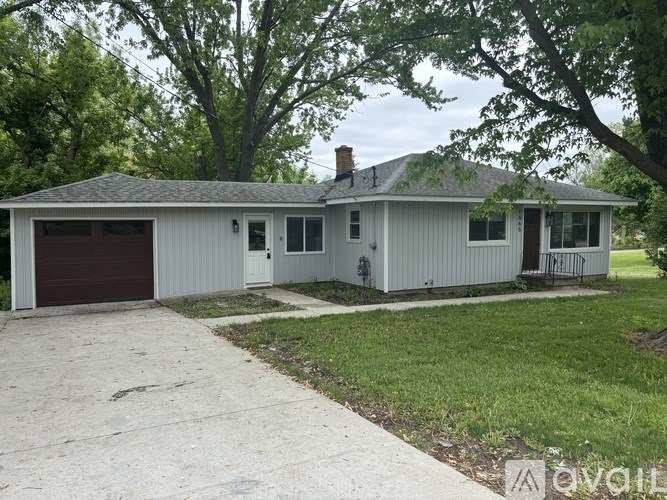 A two-story house with a garage and a driveway.