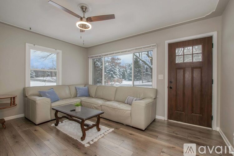 A living room with a white couch and a wooden coffee table.