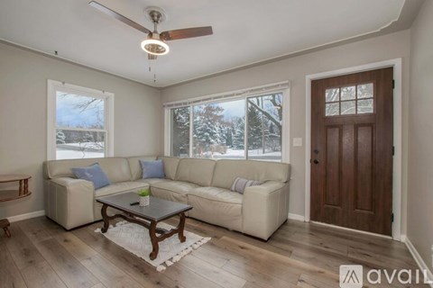 A living room with a white couch and a wooden coffee table.