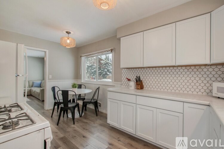 A kitchen with white cabinets and a tile backsplash.