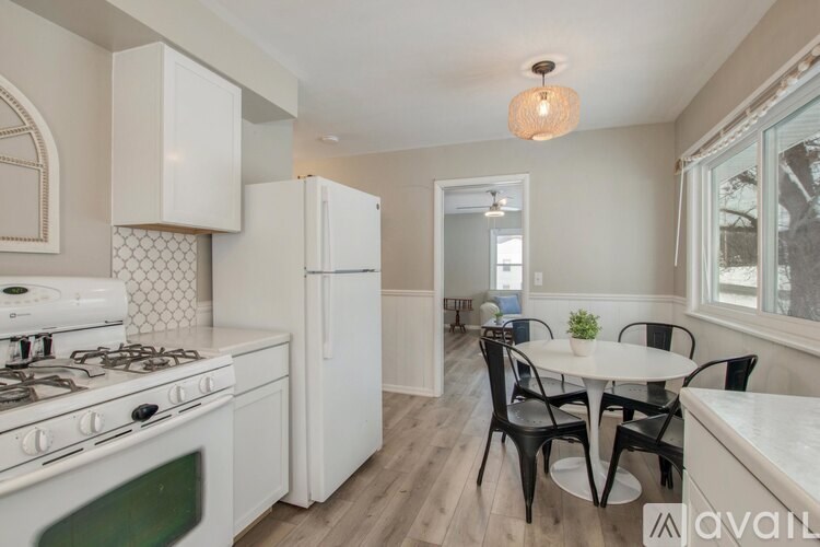 A kitchen with a white stove top oven and a white refrigerator.