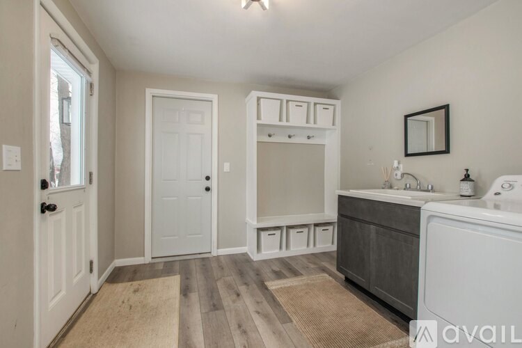A bathroom with a white cabinet, a sink, and a mirror.