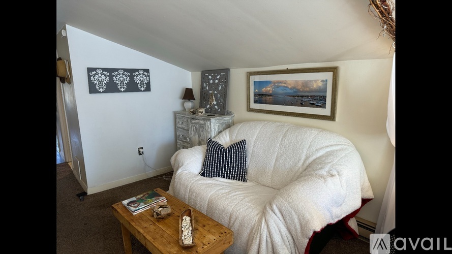 A living room with a white couch and a wooden coffee table.