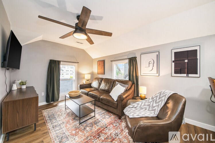 A living room with a brown leather chair and a glass coffee table.