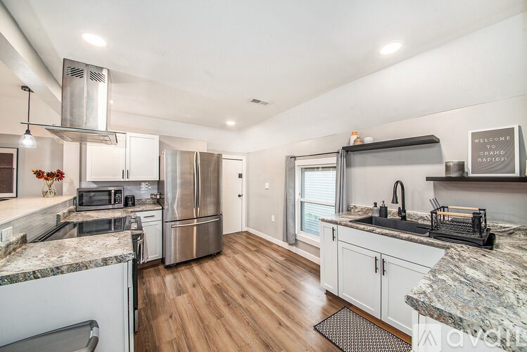 A kitchen with a granite countertop and stainless steel appliances.