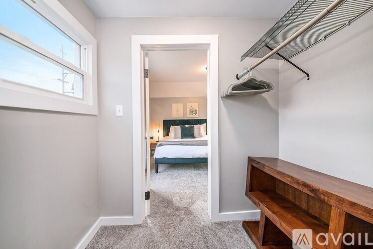A room with a bed, a window, and a wooden bench.
