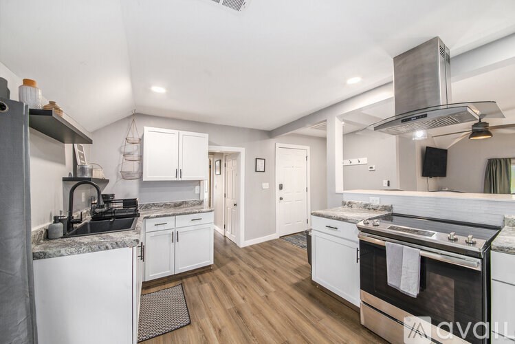 A kitchen with white appliances and wooden floors.