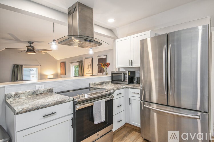 A modern kitchen with stainless steel appliances and white cabinets.