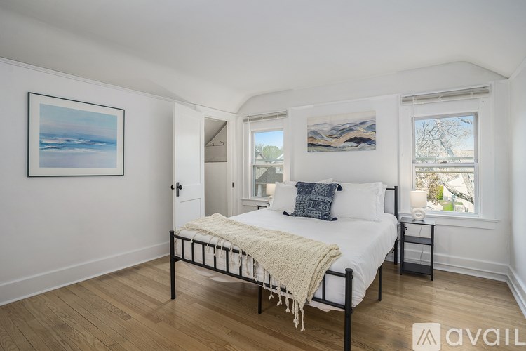 A bedroom with a bed, a nightstand, and a window.