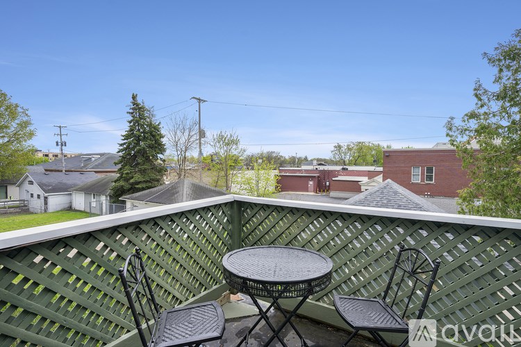 A patio with a table and chairs overlooking a residential area.