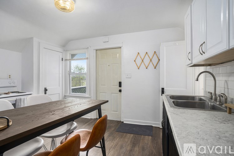 A kitchen with a table and chairs in front of a window.