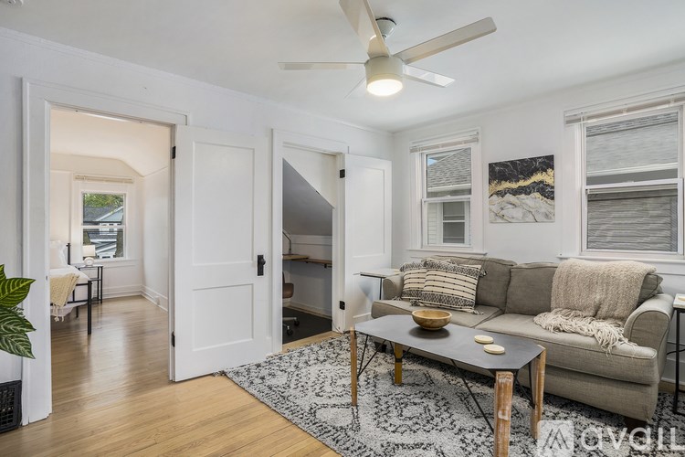 A living room with a couch, a coffee table, and a ceiling fan.