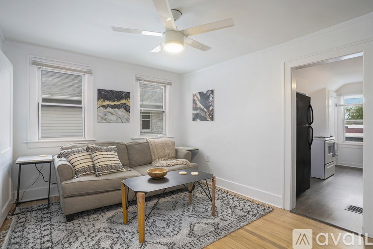 A living room with a couch, a coffee table, and a ceiling fan.