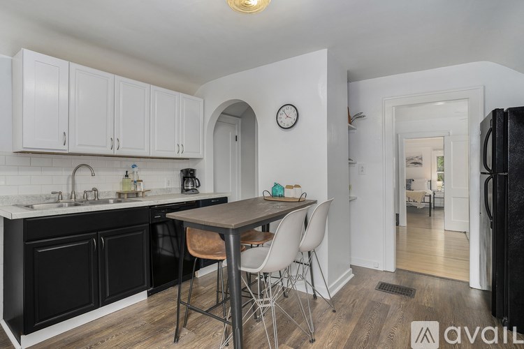A kitchen with black cabinets and a wooden table.