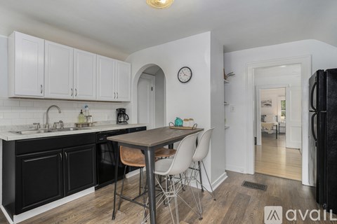 A kitchen with black cabinets and a wooden table.
